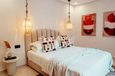 a bedroom with a bed with white sheets and pillows at Luxury 4 bed apartment In the heart of Guilez! in Marrakech
