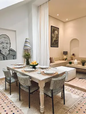 a living room with a table and chairs and a couch at Riad Baba in Marrakech