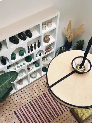 a room with a table and a shelf of vases at Riad Baba in Marrakech