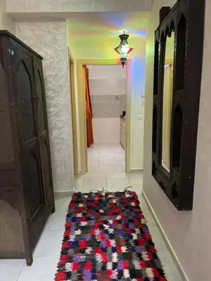 a hallway with a rug on the floor next to a bathroom at lUXEE APPARTEMENTN BELLE in Marrakech
