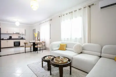 a living room with a white couch and a table at Luxury apartment with pool in Marrakech