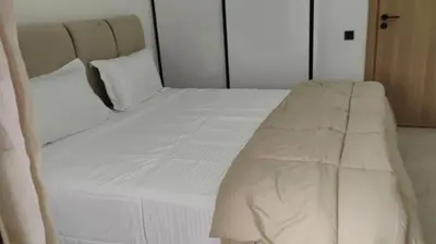 a large white bed with white sheets and pillows at Luxury apartment 2 min Train Station 10 min Airport in Marrakech