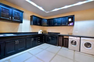 a kitchen with black cabinets and a washer and dryer at Luxury Villa in Marrakech