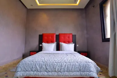 a bedroom with a large bed with red headboards at Luxury Villa in Marrakech