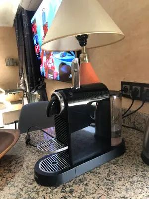 a black coffee maker with a lamp on a counter at Bel appartement central in Marrakech