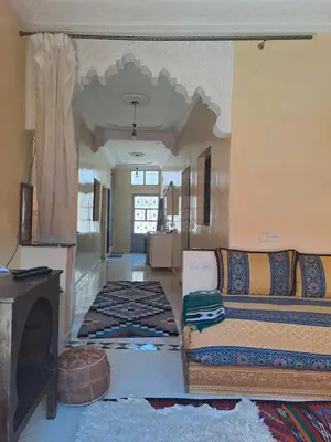 a living room with a couch and a fireplace at Small villa with heated pool & garage for families in Marrakech