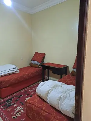 a room with two beds and a table in it at Small villa with heated pool & garage for families in Marrakech