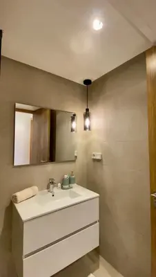 a bathroom with a white sink and a mirror at Alba cosy - 3 piscines, Wifi HD, Parc de jeux in Marrakech