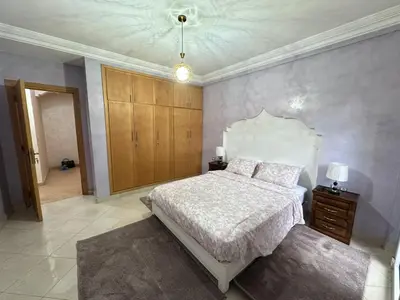 a bedroom with a bed with a white comforter at Élégante Villa 3 Chambres avec Jardin & Piscine Targa Afak Marrakech in Marrakech