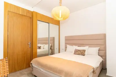 a bedroom with a large bed and a chandelier at Appartement gueliz, hyper centre in Marrakech