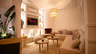 a living room with a couch and a clock on the wall at Private Riad Loulou Zitoun - rooftops - 2 pools - 4 rooms in Marrakech