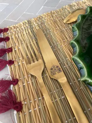 a bamboo table with two wooden spoons and purple thread at Private Riad Loulou Zitoun - rooftops - 2 pools - 4 rooms in Marrakech