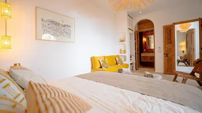 a bedroom with a large bed and a yellow chair at Private Riad Loulou Zitoun - rooftops - 2 pools - 4 rooms in Marrakech