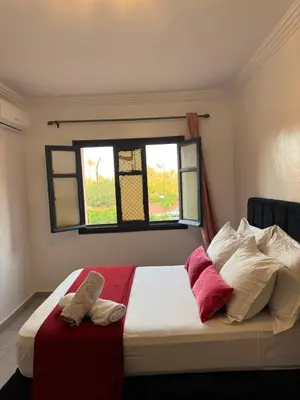 a bedroom with a bed with two pillows and a window at Golden palm appart in Marrakech