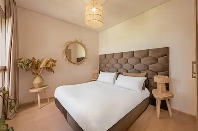 a bedroom with a large white bed and a mirror at Z Series Cozy and Modern Apartment in Marrakech