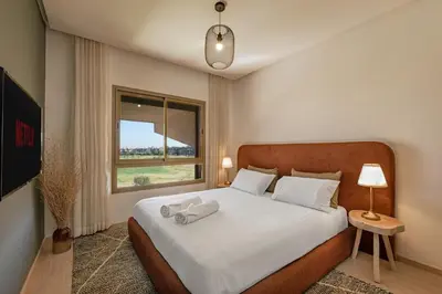 a bedroom with a bed with white sheets and a window at Z Series Cozy and Modern Apartment in Marrakech