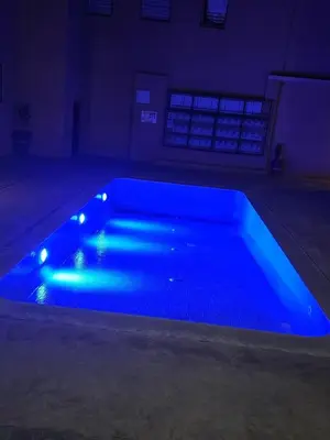 a blue pool with lights in a dark room at Beautiful apartment with children's pool in Marrakech
