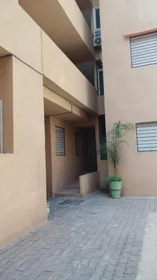 a building with a potted plant in front of it at Beautiful apartment with children's pool in Marrakech
