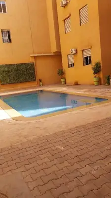 a swimming pool in front of a building at Beautiful apartment with children's pool in Marrakech