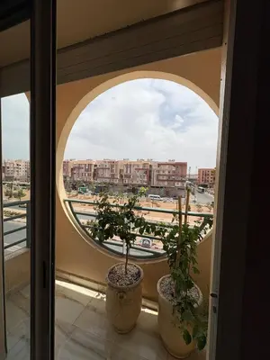 a window with two potted plants on a balcony at Elegant apartment near the airport in Marrakech