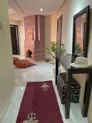a living room with a fireplace and a red rug at Vue Fontaine appart in Marrakech