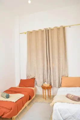 two beds in a room with a curtain at Quiet apartment of traditional Moroccan in Marrakech