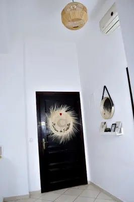 a black door in a white room with a wreath on it at Quiet apartment of traditional Moroccan in Marrakech