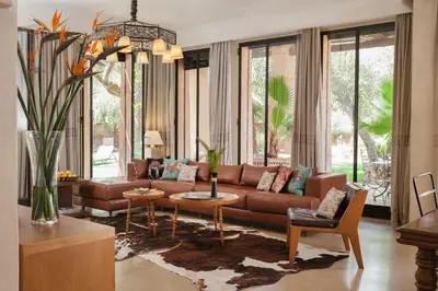 a living room with a brown couch and some windows at Lankah - Authentic villa with private heated pool close to city center in Douar Caïd Layadi