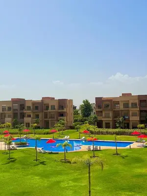 a large pool with red umbrellas in a park at Luxury Apartment & Atlas View in Marrakech