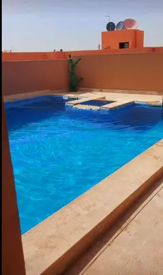 a swimming pool with blue water in a building at La Terrasse in Marrakech