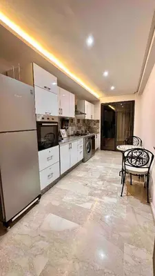 a kitchen with a refrigerator and a table in it at GYM POOL Flat Marrakech Central City in Marrakech