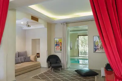 a living room with a couch and a chair at Adnaa - Modern Villa with 2 pools, sauna, hammam, tennis court & home cinema in Douar Caïd Layadi