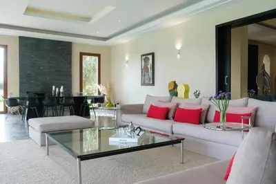 a living room with a couch and a table at Adnaa - Modern Villa with 2 pools, sauna, hammam, tennis court & home cinema in Douar Caïd Layadi