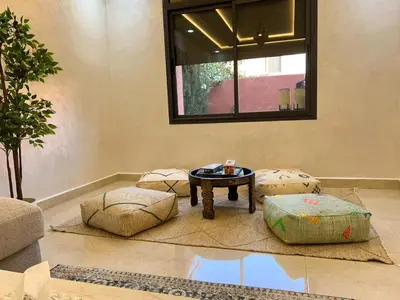 a living room with a table and some ottoman at Villa Privèe avec Piscine Chaufèe à 5min de Gueliz in Marrakech