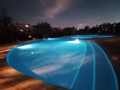 an empty swimming pool at night with lights at Dar Saad Atlas golf in Marrakech