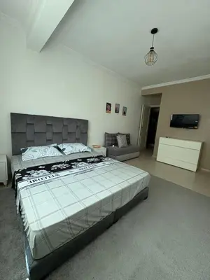 a bedroom with a large bed and a couch at Albaraka building in Marrakech