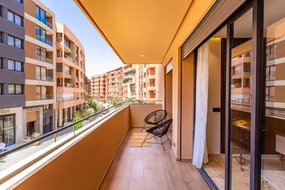 a balcony with a chair and a view of a city at La Parenthèse Urbaine - Patio Berbère in Marrakech