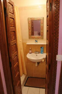 a bathroom with a sink and a mirror at Ryad OMS Marrakech in Marrakech