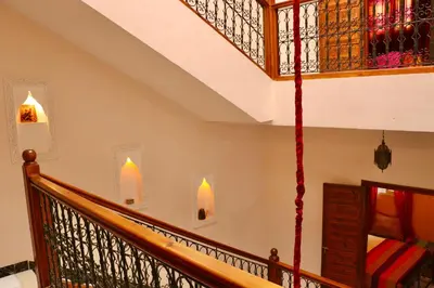 a staircase with a wooden rail and stained glass windows at Ryad OMS Marrakech in Marrakech