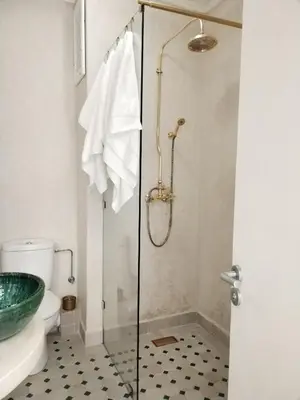 a bathroom with a shower with a toilet and a sink at White in Marrakech