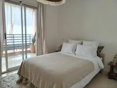 a white bed in a room with a large window at White in Marrakech
