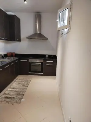 a kitchen with black cabinets and a stove top oven at White in Marrakech