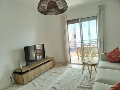 a living room with a tv and a couch at White in Marrakech