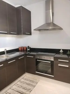 a kitchen with brown cabinets and a stove top oven at White in Marrakech