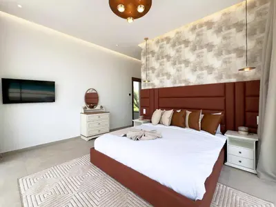 a bedroom with a large bed and a tv at Villa Signature - Élégance , Confort en Double in Marrakech