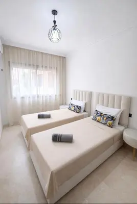 a bedroom with two beds and a couch at Duplex Moderne et Confort in Marrakech