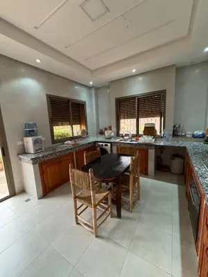 a large kitchen with a wooden table and chairs at Villa Benben 6 minutes du Grand Stade de Marrakech in Marrakech