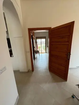 a hallway with a wooden door in a house at Villa Benben 6 minutes du Grand Stade de Marrakech in Marrakech
