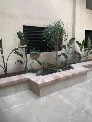 a concrete bench with plants in a building at Stylish 1 Bedroom Apartment 2 Min to Train and Bus Stations 12 Min to Airport in Marrakech