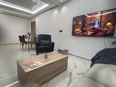 a living room with a tv on the wall at Stylish 1 Bedroom Apartment 2 Min to Train and Bus Stations 12 Min to Airport in Marrakech